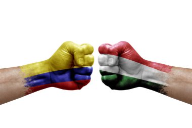 Two hands punch to each others on white background. Country flags painted fists, conflict crisis concept between colombia and hungary