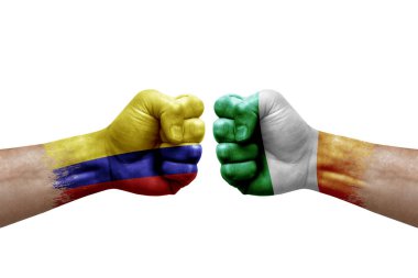 Two hands punch to each others on white background. Country flags painted fists, conflict crisis concept between colombia and ireland