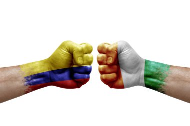 Two hands punch to each others on white background. Country flags painted fists, conflict crisis concept between colombia and ivory coast
