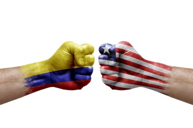 Two hands punch to each others on white background. Country flags painted fists, conflict crisis concept between colombia and liberia
