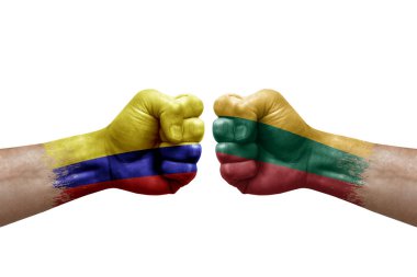 Two hands punch to each others on white background. Country flags painted fists, conflict crisis concept between colombia and lithuania