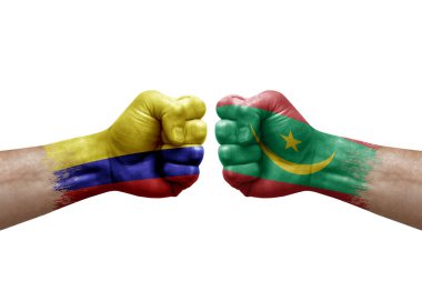 Two hands punch to each others on white background. Country flags painted fists, conflict crisis concept between colombia and mauritania
