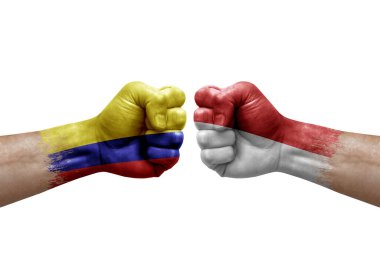 Two hands punch to each others on white background. Country flags painted fists, conflict crisis concept between colombia and monaco