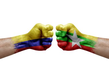 Two hands punch to each others on white background. Country flags painted fists, conflict crisis concept between colombia and myanmar