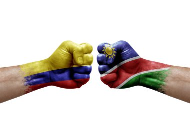 Two hands punch to each others on white background. Country flags painted fists, conflict crisis concept between colombia and namibia