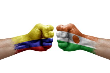 Two hands punch to each others on white background. Country flags painted fists, conflict crisis concept between colombia and niger