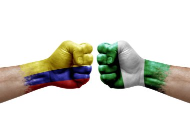 Two hands punch to each others on white background. Country flags painted fists, conflict crisis concept between colombia and nigeria