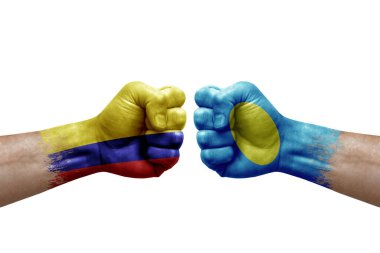 Two hands punch to each others on white background. Country flags painted fists, conflict crisis concept between colombia and palau