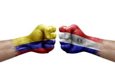 Two hands punch to each others on white background. Country flags painted fists, conflict crisis concept between colombia and paraguay
