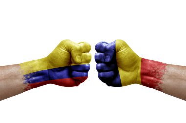 Two hands punch to each others on white background. Country flags painted fists, conflict crisis concept between colombia and romania