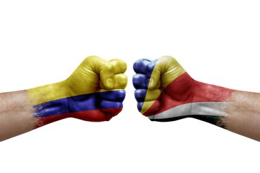 Two hands punch to each others on white background. Country flags painted fists, conflict crisis concept between colombia and seychelles