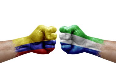 Two hands punch to each others on white background. Country flags painted fists, conflict crisis concept between colombia and sierra leone