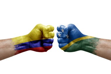 Two hands punch to each others on white background. Country flags painted fists, conflict crisis concept between colombia and solomon islands