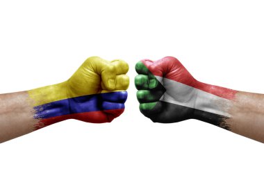 Two hands punch to each others on white background. Country flags painted fists, conflict crisis concept between colombia and sudan