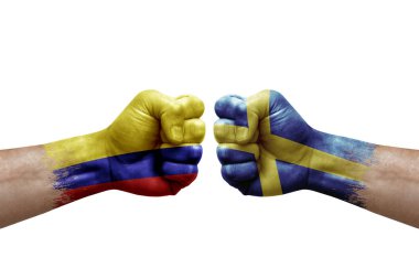Two hands punch to each others on white background. Country flags painted fists, conflict crisis concept between colombia and sweden