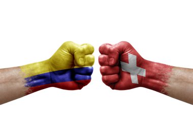 Two hands punch to each others on white background. Country flags painted fists, conflict crisis concept between colombia and switzerland
