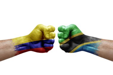 Two hands punch to each others on white background. Country flags painted fists, conflict crisis concept between colombia and tanzania