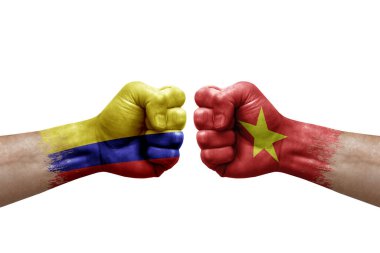 Two hands punch to each others on white background. Country flags painted fists, conflict crisis concept between colombia and vietnam