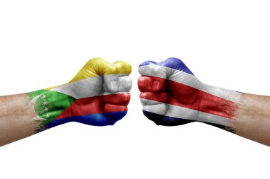 Two hands punch to each others on white background. Country flags painted fists, conflict crisis concept between comoros and costa rica