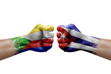 Two hands punch to each others on white background. Country flags painted fists, conflict crisis concept between comoros and cuba