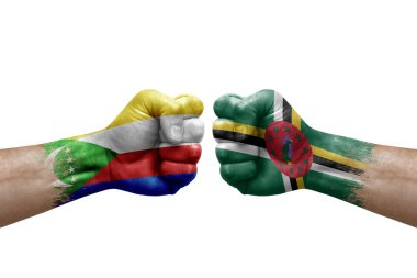 Two hands punch to each others on white background. Country flags painted fists, conflict crisis concept between comoros and dominica