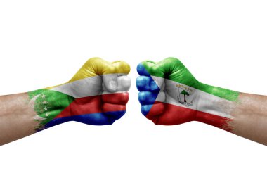 Two hands punch to each others on white background. Country flags painted fists, conflict crisis concept between comoros and equatorial guinea