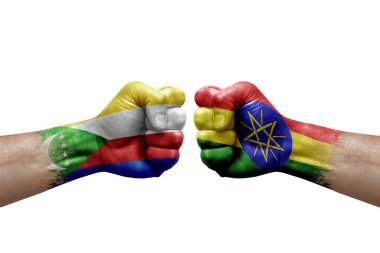 Two hands punch to each others on white background. Country flags painted fists, conflict crisis concept between comoros and ethiopia