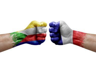 Two hands punch to each others on white background. Country flags painted fists, conflict crisis concept between comoros and france