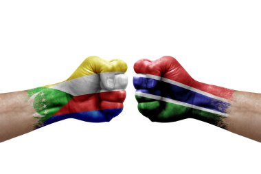 Two hands punch to each others on white background. Country flags painted fists, conflict crisis concept between comoros and gambia