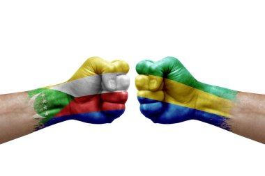 Two hands punch to each others on white background. Country flags painted fists, conflict crisis concept between comoros and gabon