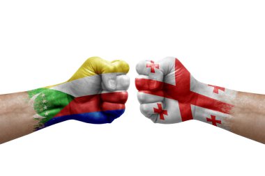 Two hands punch to each others on white background. Country flags painted fists, conflict crisis concept between comoros and georgia