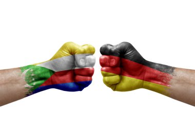 Two hands punch to each others on white background. Country flags painted fists, conflict crisis concept between comoros and germany