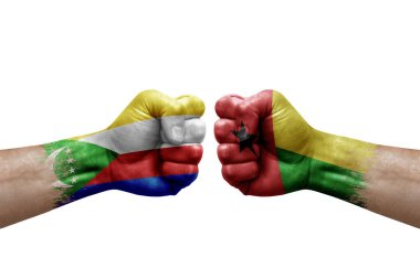Two hands punch to each others on white background. Country flags painted fists, conflict crisis concept between comoros and guinea-bissau