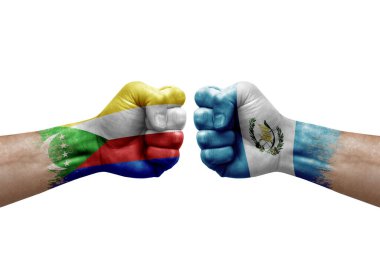Two hands punch to each others on white background. Country flags painted fists, conflict crisis concept between comoros and guatemala