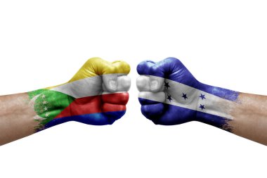 Two hands punch to each others on white background. Country flags painted fists, conflict crisis concept between comoros and honduras