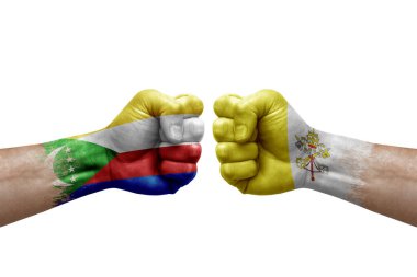 Two hands punch to each others on white background. Country flags painted fists, conflict crisis concept between comoros and holy see