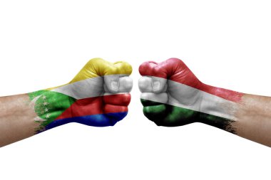Two hands punch to each others on white background. Country flags painted fists, conflict crisis concept between comoros and hungary