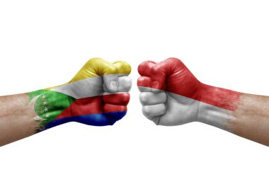 Two hands punch to each others on white background. Country flags painted fists, conflict crisis concept between comoros and indonesia