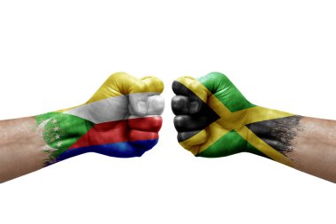 Two hands punch to each others on white background. Country flags painted fists, conflict crisis concept between comoros and jamaica