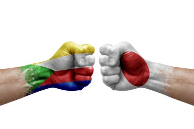 Two hands punch to each others on white background. Country flags painted fists, conflict crisis concept between comoros and japan