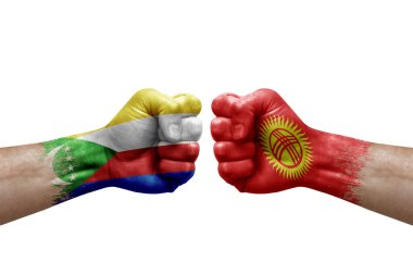 Two hands punch to each others on white background. Country flags painted fists, conflict crisis concept between comoros and kyrgyzstan