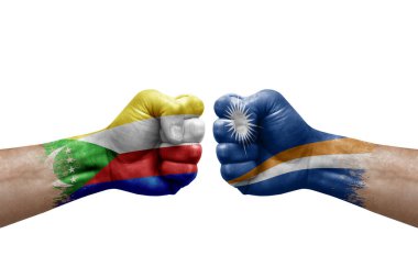 Two hands punch to each others on white background. Country flags painted fists, conflict crisis concept between comoros and marshall islands