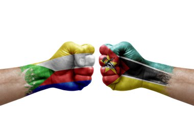 Two hands punch to each others on white background. Country flags painted fists, conflict crisis concept between comoros and mozambique