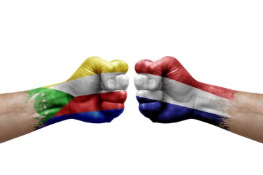Two hands punch to each others on white background. Country flags painted fists, conflict crisis concept between comoros and netherlands