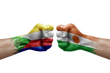 Two hands punch to each others on white background. Country flags painted fists, conflict crisis concept between comoros and niger