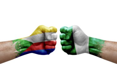 Two hands punch to each others on white background. Country flags painted fists, conflict crisis concept between comoros and nigeria
