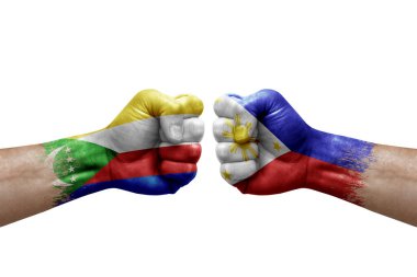 Two hands punch to each others on white background. Country flags painted fists, conflict crisis concept between comoros and philippines