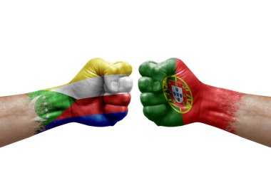 Two hands punch to each others on white background. Country flags painted fists, conflict crisis concept between comoros and portugal