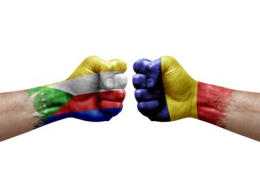 Two hands punch to each others on white background. Country flags painted fists, conflict crisis concept between comoros and romania