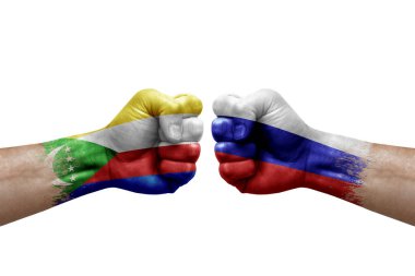 Two hands punch to each others on white background. Country flags painted fists, conflict crisis concept between comoros and russia